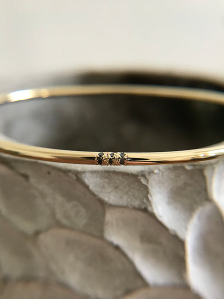 Minimalistic Gold Cuff Bracelet with three small black diamonds