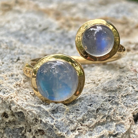 Gold ring with two large moonstones and diamonds along the side.