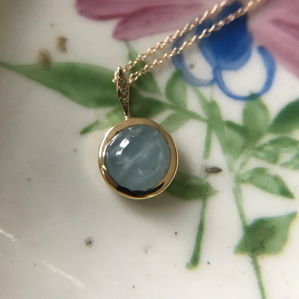Gold pendant with large aquamarine or moonstone stone and three diamonds on the gold bail.