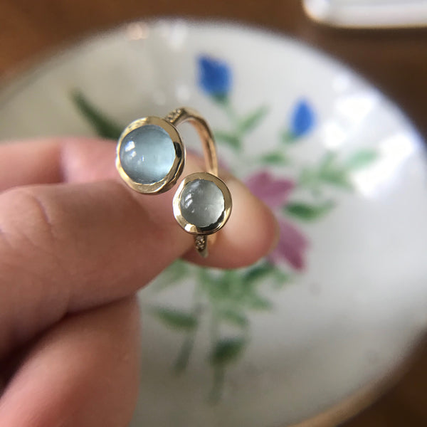 Three-quarter shot of gold ring with moonstone or aquamarine.