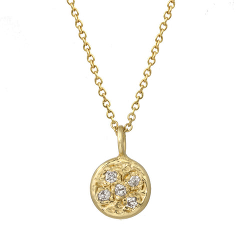 Circular pendant with bezeled pebble diamonds on a gold chain.