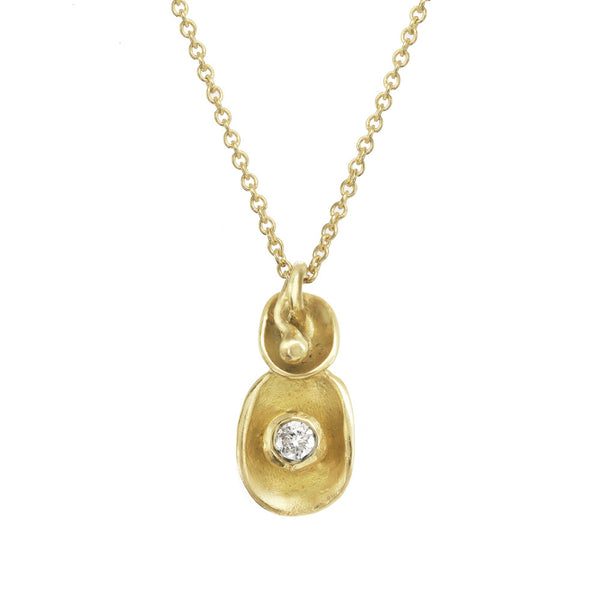 Waterlily inspired gold pendant with tiny diamond on a gold chain.
